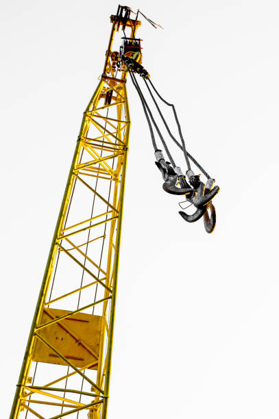 istock Four empty yellow crane hook hanging down isolated on white background 868743658