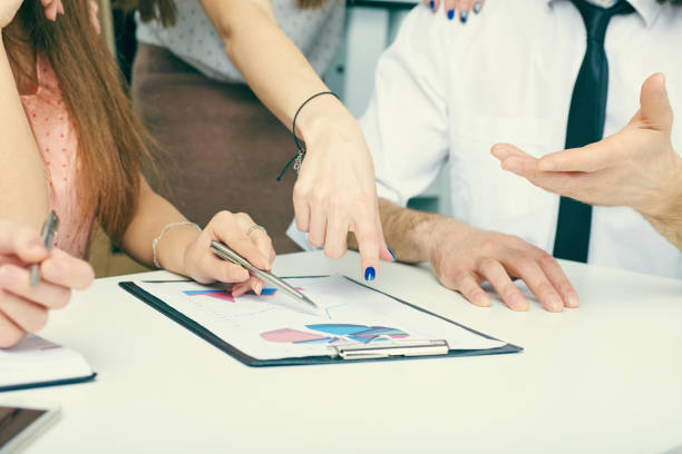 istock Group of business people looking at the clipboard with graphics. 868751986