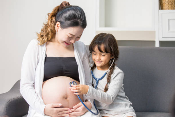 istock Little cute girl using stethoscope check stomach her mother 868752464