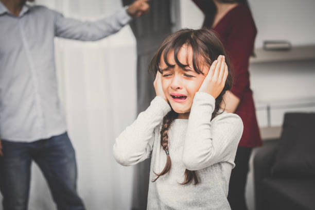 Little girl crying while parents quarrel. Closing the ears, 5-10 years old, vintage tone. Little girl crying while parents quarrel. Closing the ears, 5-10 years old, vintage tone. arguing couple divorce family stock pictures, royalty-free photos & images