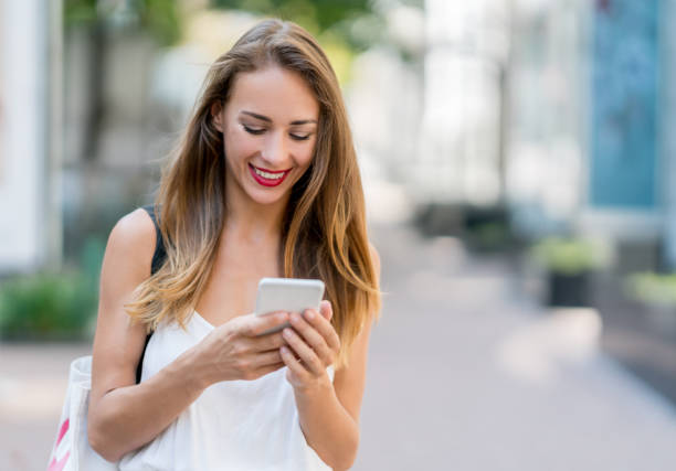 istock Beautiful woman using app on her cell phone outdoors 868762076
