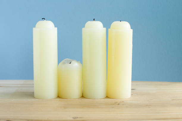 istock yellow candles on wooden table 868769066