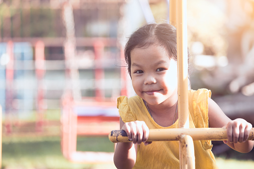 Happy asian little child girl having fun to play on rocking horse in playground