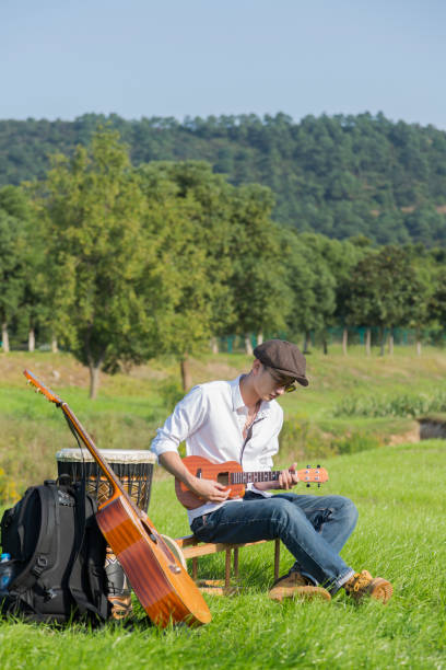 istock young man playing small guitar on lawn 868772970