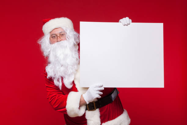 istock Santa Claus pointing in blank advertisement banner isolated on red background with copy space 868773064