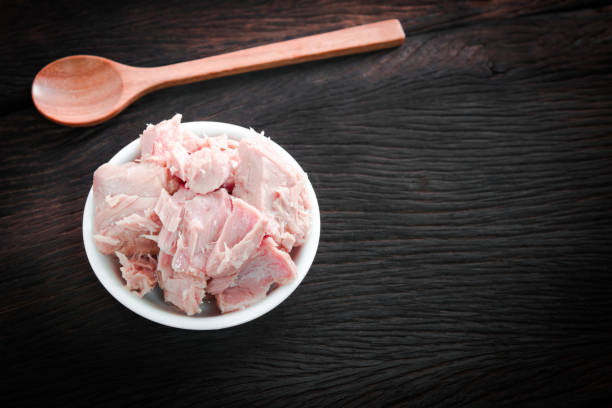 istock bowl of tuna chunks on wood table background. Dark tone 868773242