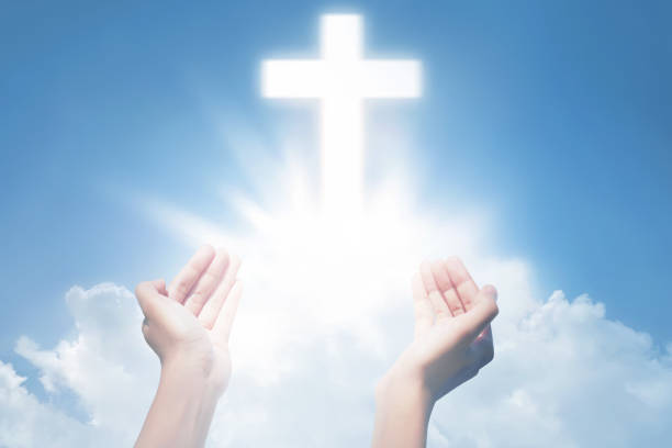 istock Human hands open palm and praying with cross 868776308
