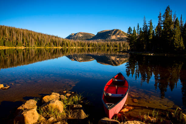 istock Canoe on shore of mountain lake 868786302