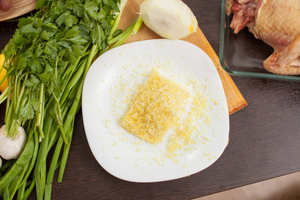 тертая лимонная цедра на тарелке на столе с зеленью - grater grated peel ingredient стоковые фото и изображения