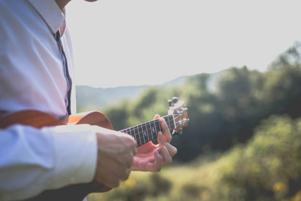 istock young man playing small guitar on lawn 868799814
