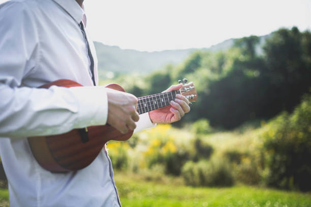 istock young man playing small guitar on lawn 868799950