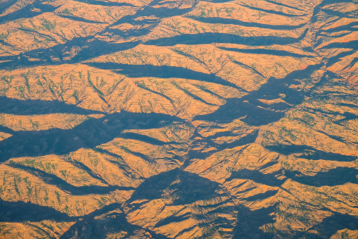 Above the mountains and ridges. Sunset color and shadows from the mountains. Texture of mountains, landscape.