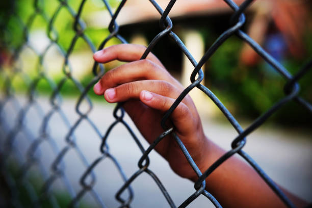 Hand in jail. Hand in jail with girl and house of detention concept, vignette effect and selective focus. child arrest stock pictures, royalty-free photos & images
