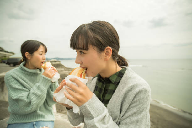 They take a sandwich lunch at the beachfront parking lot. .