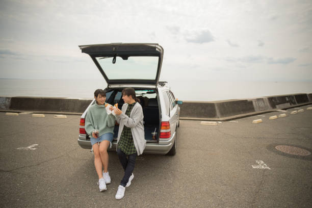 eles levam um almoço sanduíche no estacionamento em frente à praia. . - beach parking lot car equipment - fotografias e filmes do acervo