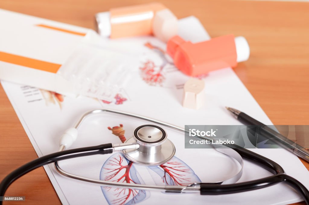 Medical stethoscope, device for asthmatics and sheet of paper with test results on table Medical stethoscope, device for asthmatics and sheet of paper with test results on the background of table Asthmatic Stock Photo