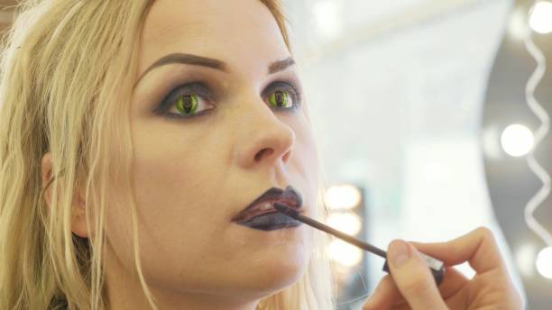 istock Process applying halloween makeup on face the young beautiful woman 868823038