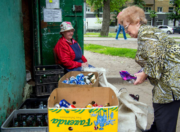 una anciana da materiales reciclables en un punto de recepción, la ciudad de vorónezh - kraft paper fotografías e imágenes de stock