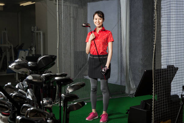 eine frau mit einem lächeln in einem golf-studio. - exercising women sport studio shot stock-fotos und bilder