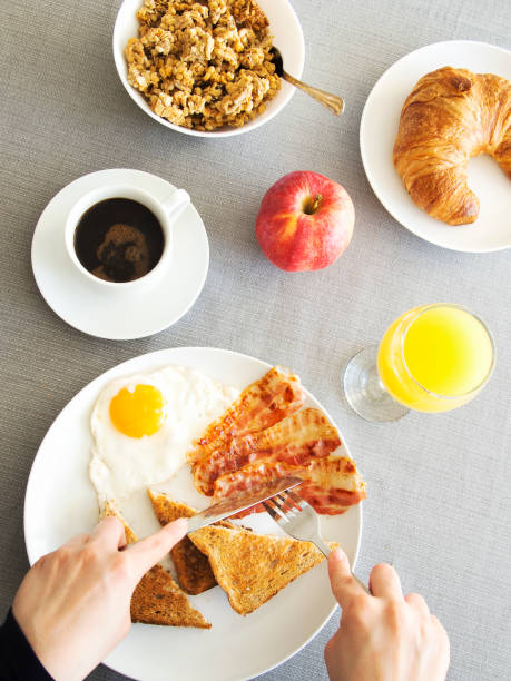 istock Breakfast table top view, woman spreading butter on toat 868826552