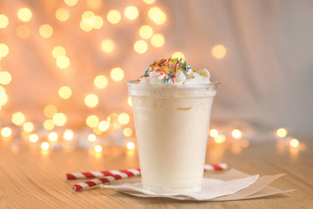 Milkshake on the background of Christmas garland Jar of Christmas milk drink on wooden rustic table with winter holiday background. Milkshake on the background of the New Year's garland whipped food photos stock pictures, royalty-free photos & images