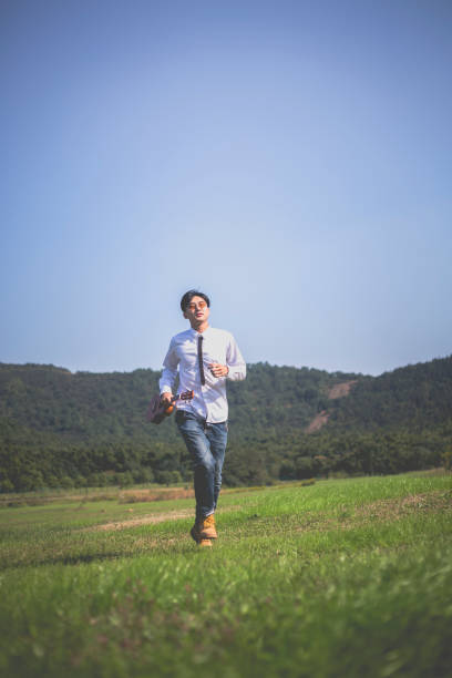 istock young enthusiastic man carrying his guitar running 868833852