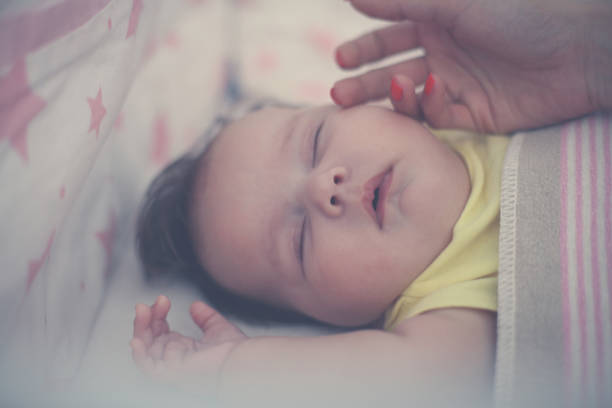 istock Mother caressing her sleepy baby. Close up. 868834382