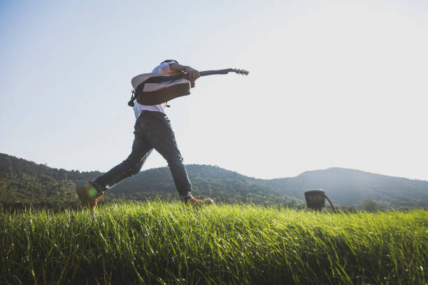 istock young enthusiastic man carrying his guitar running 868834524