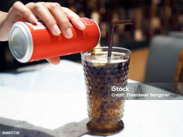 Pouring Cola Over Ice Cube In Clear Glass With Straw Stock Photo - Download Image Now