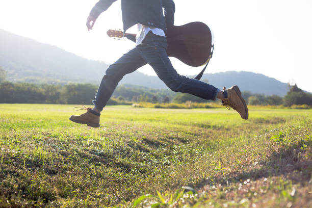 istock young enthusiastic man carrying his guitar running 868837952