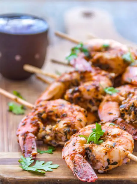 Grilled Shrimp With Dried Herbs and Cilantro Served On a Wooden Base.