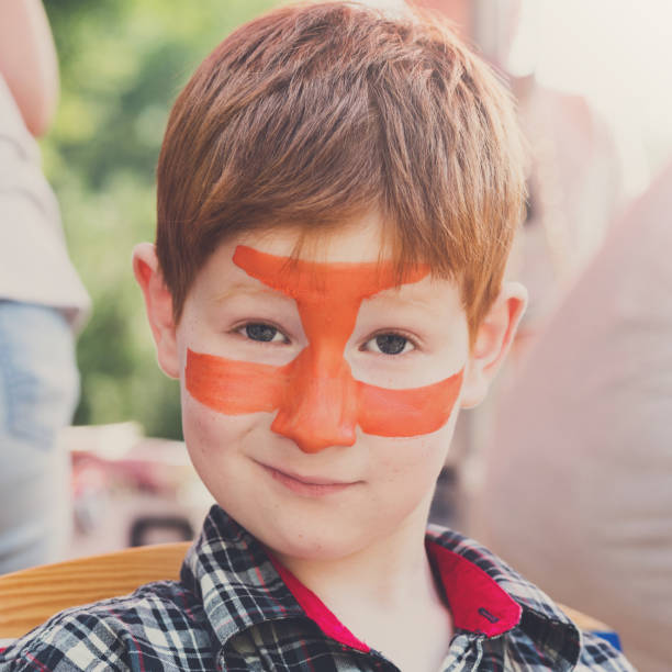 istock Child boy face painting, making tiger eyes process 868840682