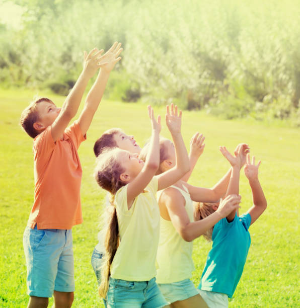 istock smiling kids jumping together in park on summer 868845322