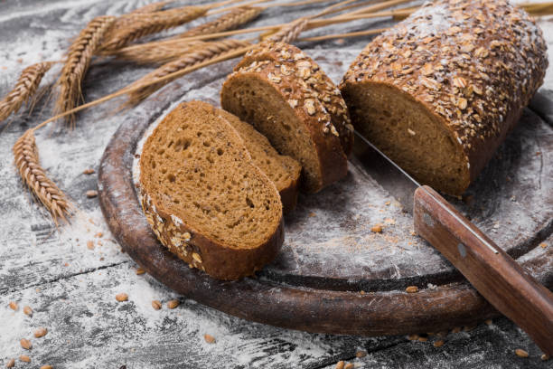 istock Bakery concept background. Whole grain rye sliced bread and knife 868845332