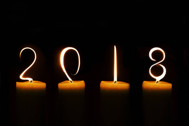 istock 2018 written with candle flames on black background 868853358