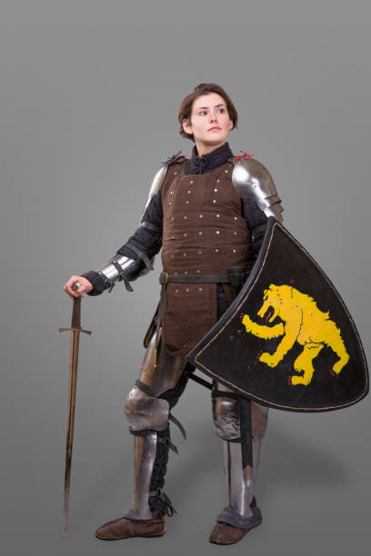девушка в доспехах с мечом рыцарь wuth щит на сером фоне - battle dress стоковые фото и изображения