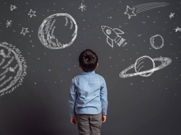 Imagination of little child Cute child in front of huge blackboard and he is dreaming. one boy only photos stock pictures, royalty-free photos & images
