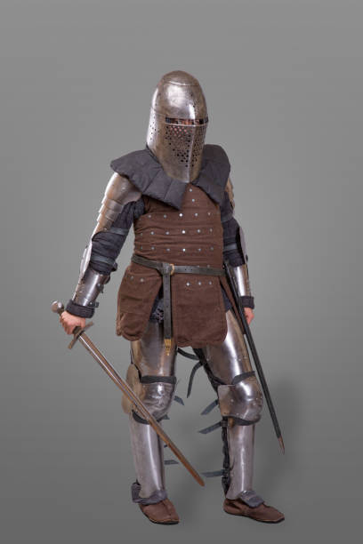 istock Armored knight in a helmet and with a sword over gray background. 868853628