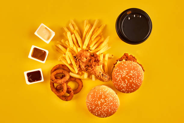 istock Fast food concept with greasy fried restaurant take out as onion rings, burger, fried chicken and french fries as a symbol of diet temptation resulting in unhealthy nutrition 868853786