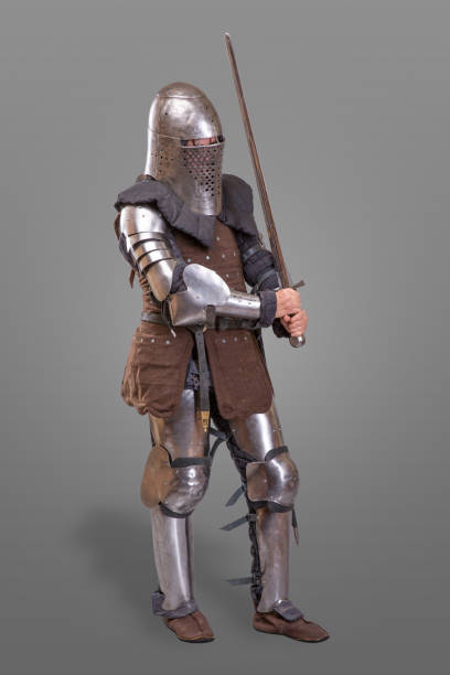 istock Armored knight in a helmet and with a sword over gray background. 868853866