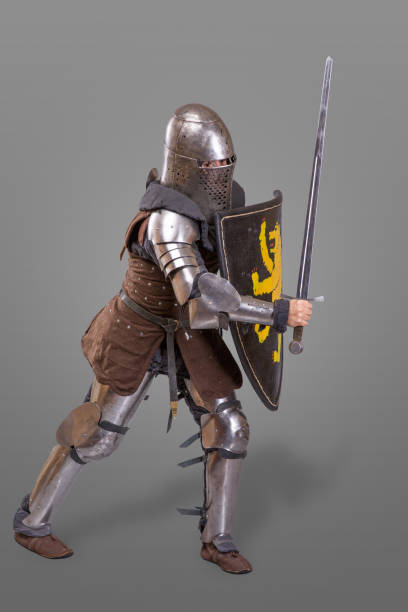 istock knight in breaths in a helmet with a sword and shield in battle over grey background 868856430