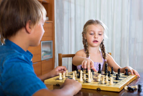 istock Brother and sister playing chess 868856608