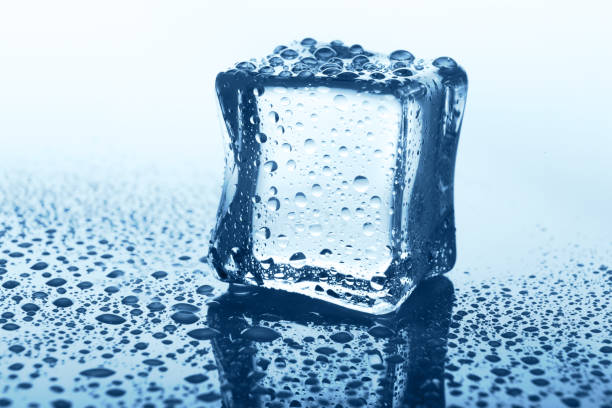 istock Transparent ice cube with reflection on blue glass with water drops 868856798