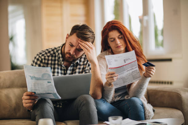 How are we going to pay these bills? Worried couple feeling frustrated while have to pay their bills over Internet. debt stock pictures, royalty-free photos & images