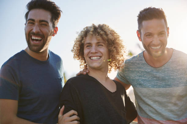istock Three handsome male friends laughing together outside 868860702
