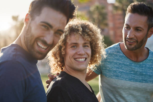 istock Handsome man standing with friends outside laughing 868860848