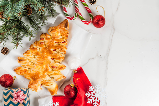 Christmas homemade stained glass cookies on marble background with bokeh lights, selective focus