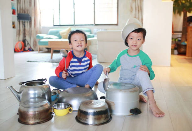istock Two brother playing on floor with pots and pans 868866702