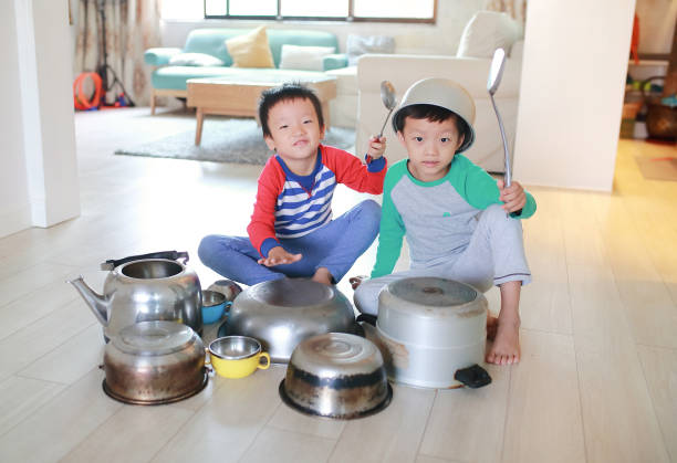 istock Two brother playing on floor with pots and pans 868866834