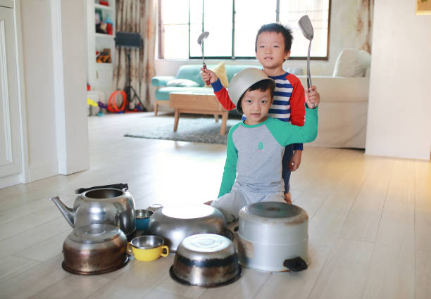 istock Two brother playing on floor with pots and pans 868866990